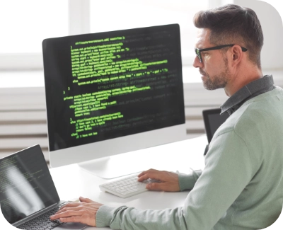 Web developer working on a computer with two monitors